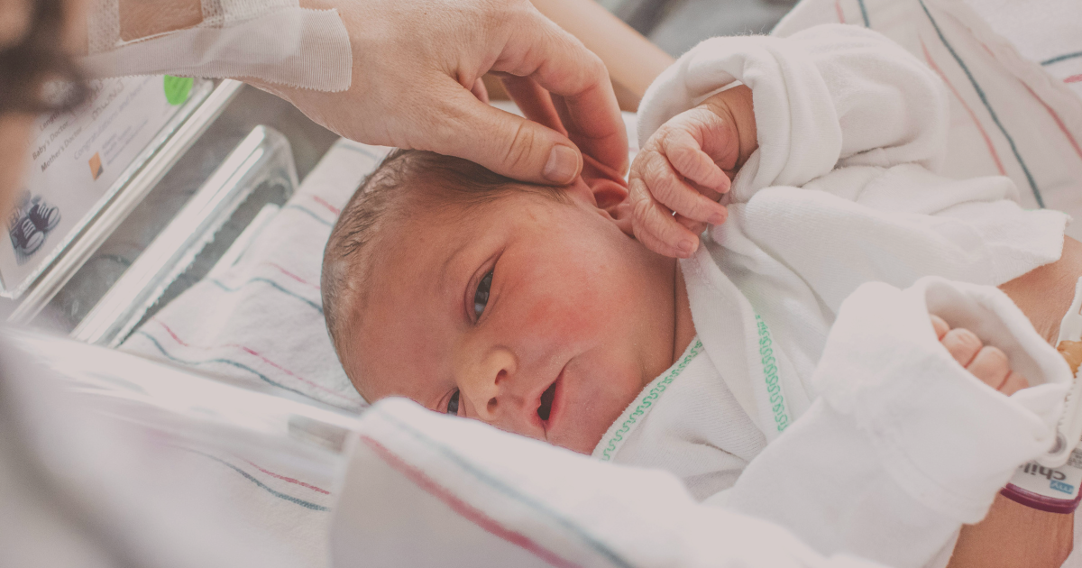 bébé né après un accouchement qui s'est bien passé, sa maman lui caresse les cheveux