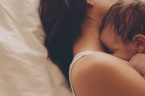 bébé dort dans les bras de sa maman